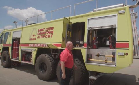 Airport employee Terry standing by a fire truck