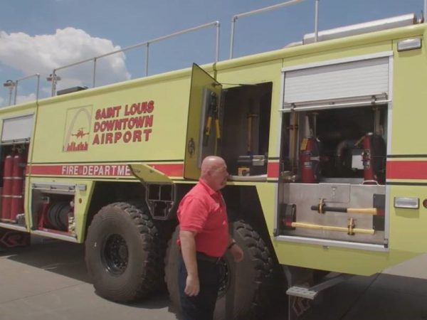 Airport employee Terry standing by a fire truck