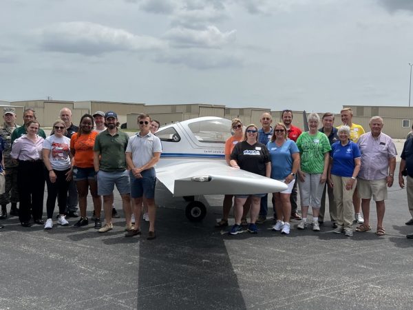 Participants and presenters posed for a group shot in front of a plane at Aviation Day for Educators