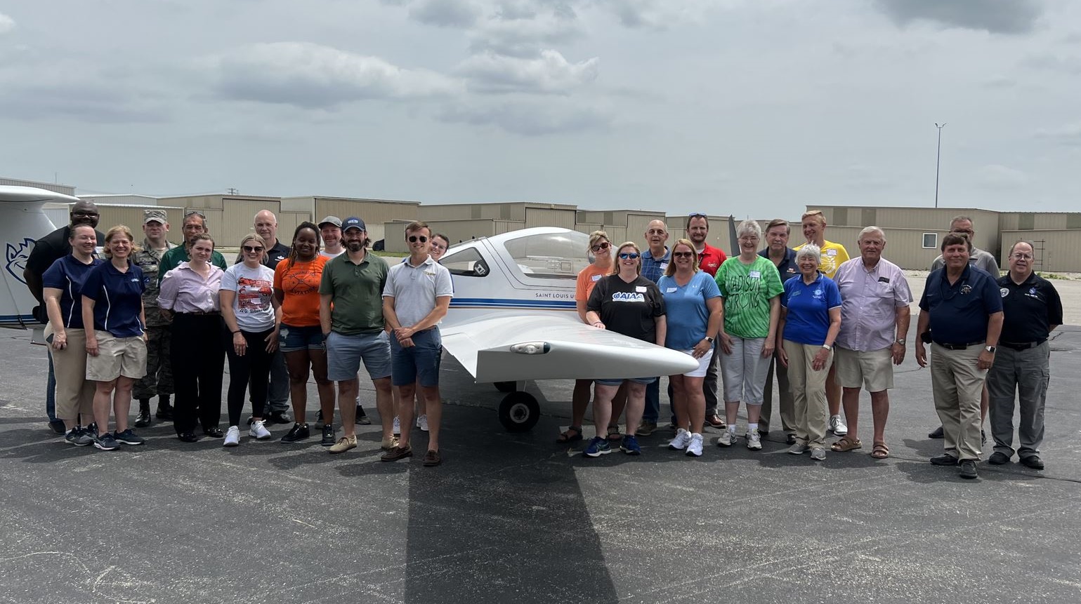 Participants and presenters posed for a group shot in front of a plane at Aviation Day for Educators
