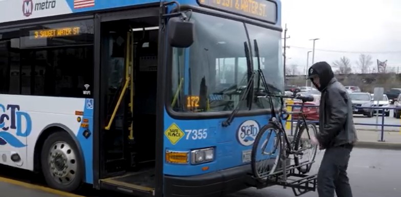 A man loads a bike onto the front of a MetroBus in Illinois.
