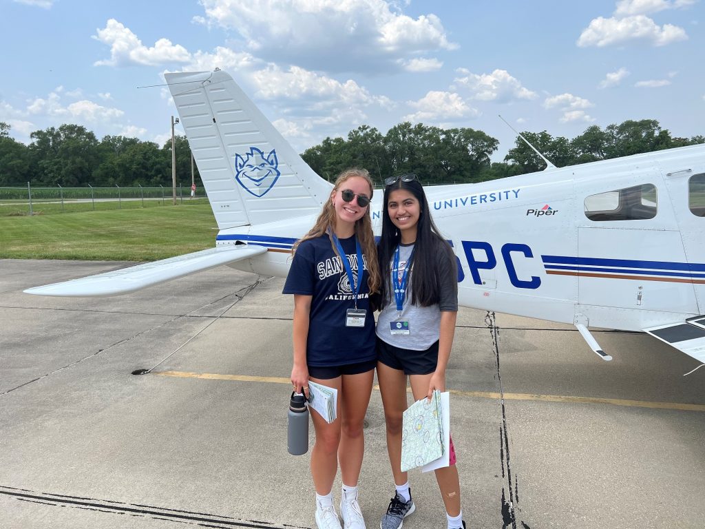 Photo of Aviation Summer Campers Autumn May and Nina Bhayani outside of a small plane.