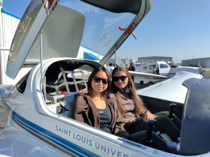 Photo of two high school seniors in small plane with cockpit open