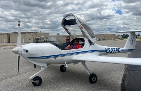 A man and a young boy sitting in an airplane at KCPS