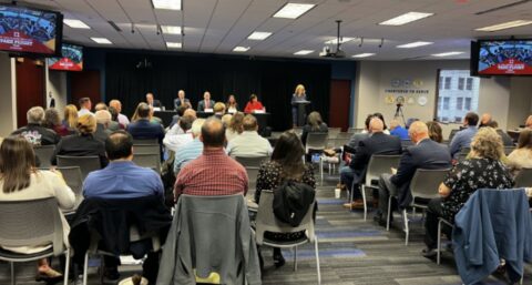 Photo of an audience listening to Mary Lamie moderate a panel of five airport directors in the BSD Board Room